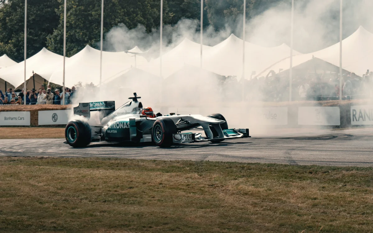 Mercedes Formula 1 race car performing a smoking burnout in front of grandstand spectators